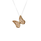 Gold butterfly charm on a ghost chain against a white background
