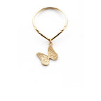 Gold butterfly charm ring on a v-shaped ring shank on a white background | Camille Torres Designs
