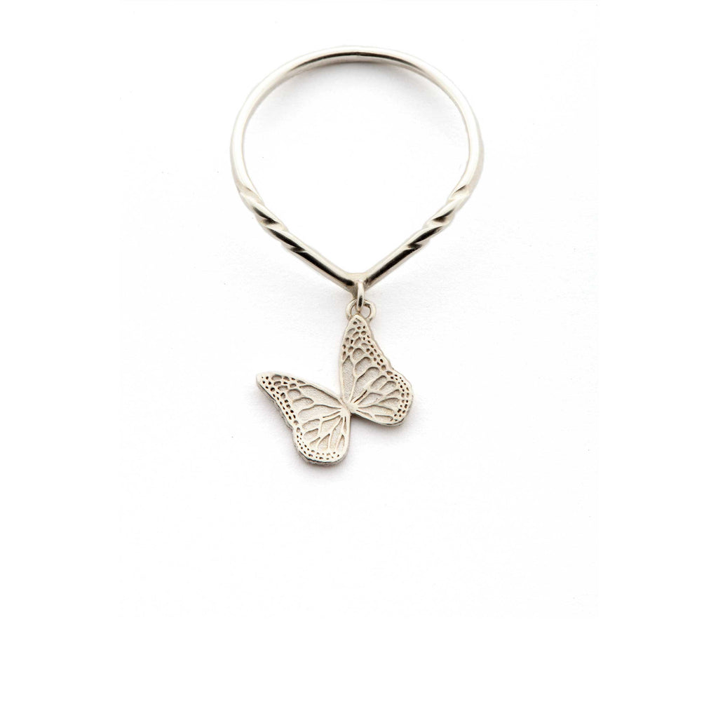 Silver butterfly charm ring on a v-shaped ring shank on a white background | Camille Torres Designs