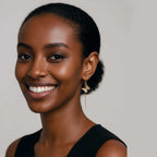 Woman wearing Whisper gold monarch butterfly threader earrings against a neutral background