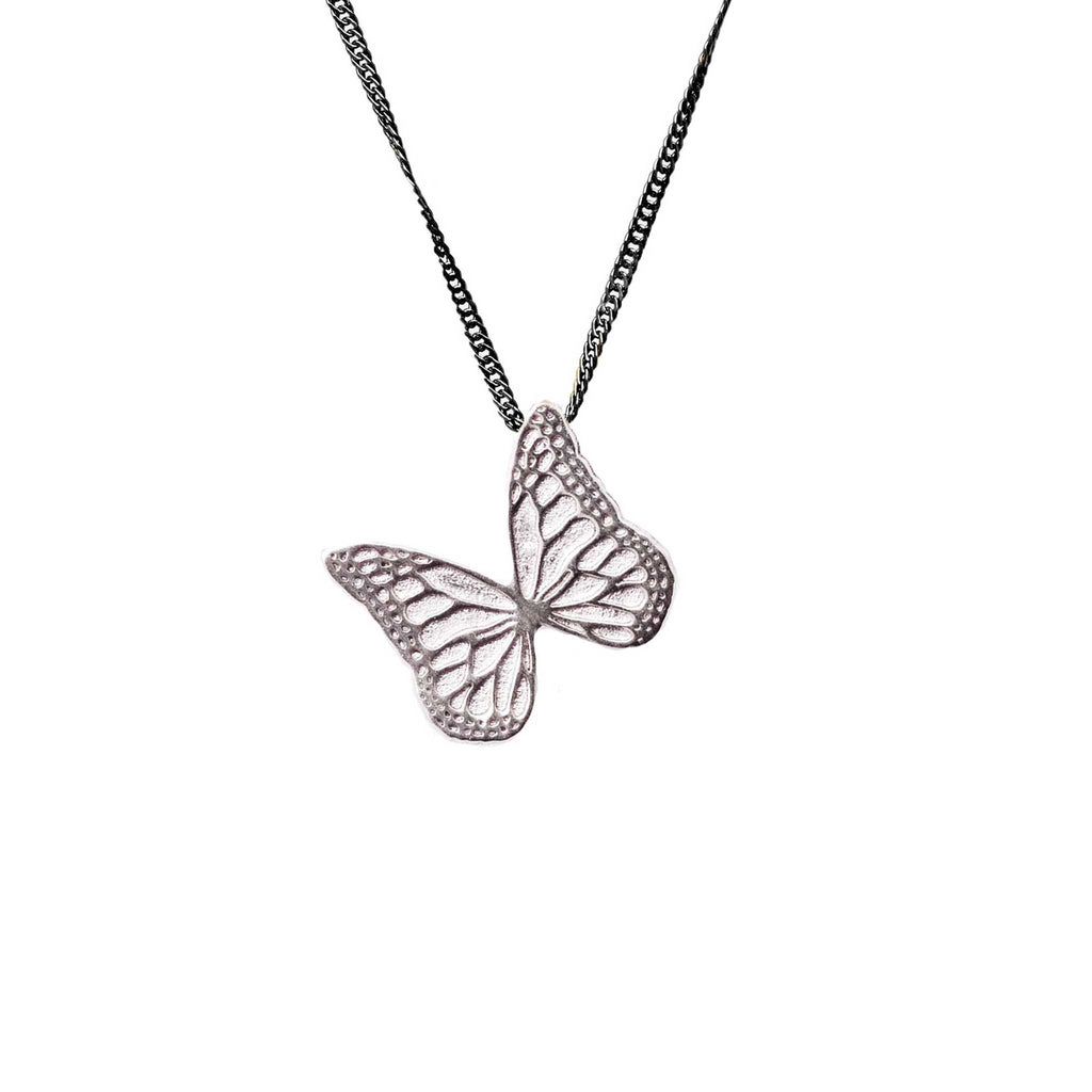 Whisper silver butterfly-shaped pendant on an oxidized chain against a white background